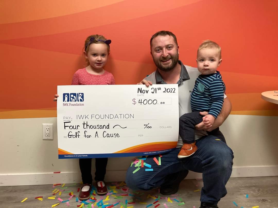 Nathan Toner and his kids holding cheque