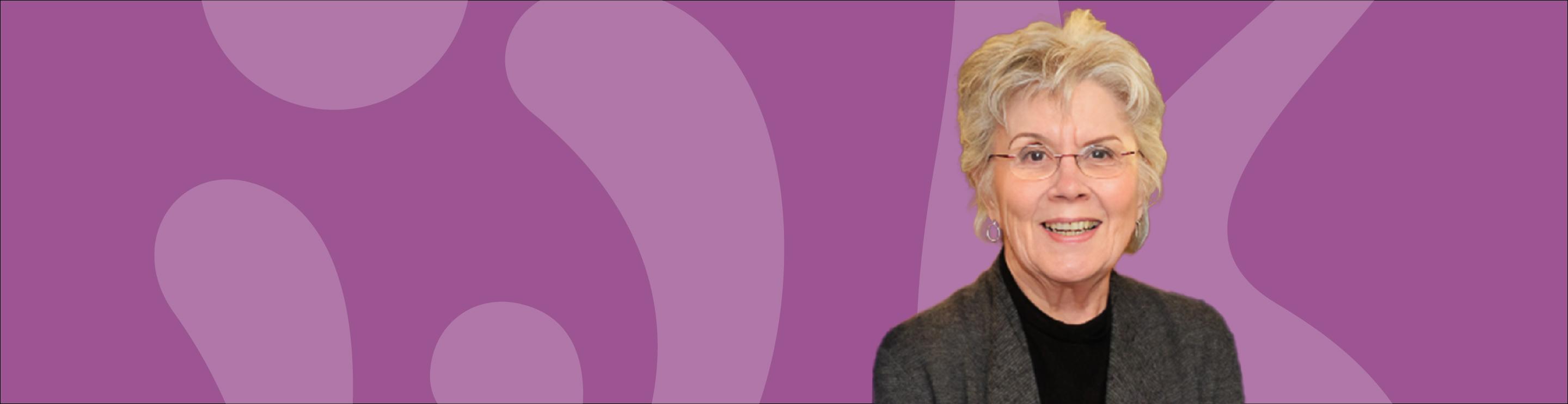 Photo of Carol Young on a purple background with light purple outlines of the W and K symbols from the IWK logo