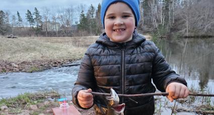 Hudson, IWK patient, holding a fish he caught.