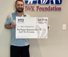 Nathan Toner holding a cheque