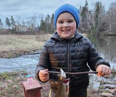 Hudson, IWK patient, holding a fish he caught.